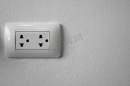 白墙上的白色通用电源插座插头。