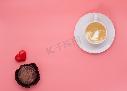 粉红色背景中的一杯咖啡松饼心
