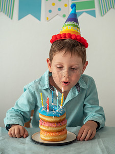 孩子吹灭生日甜甜圈蛋糕上的蜡烛