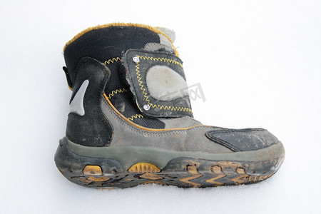 冬季雪地靴摄影照片_用过的冬靴躺在雪地里