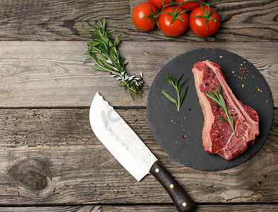 石纹板摄影照片_一块新鲜的牛肉，带香料的黑板上的西冷牛排