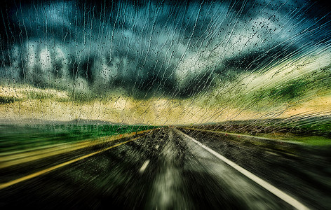 滴水不漏摄影照片_危险的模糊的驾驶汽车在雨和湿滑的路