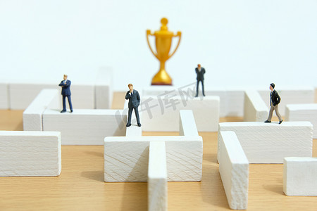 商业战略概念照片 — 商人在迷宫迷宫中寻找金奖杯的缩影