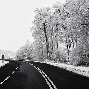 下雪路摄影照片_有积雪的风景的空的路。