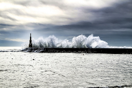 巨浪拍打着防波堤和灯塔