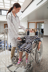 女医生对坐在轮椅和颈托上的孩子微笑