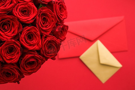艺术传达摄影照片_情人节的情书和送花服务、豪华的红玫瑰花束和红色背景的卡片信封
