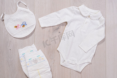 白色婴儿衣服、尿布和婴儿围嘴。