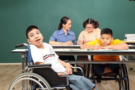 亚洲残疾儿童 或者，一名自闭症儿童在课桌前与老师一起学习阅读、写作和训练他们的手和手指肌肉。