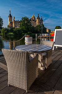 波林摄影照片_咖啡馆里空荡荡的椅子，背景是什未林一座美丽的城堡。