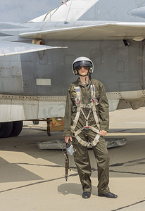 军事机场摄影照片_头盔的军事飞行员站在喷气式飞机附近