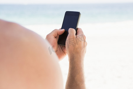 在海滩上使用智能手机的人