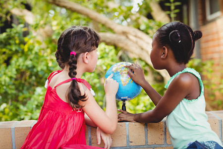 两个女孩指着地球仪的背面图