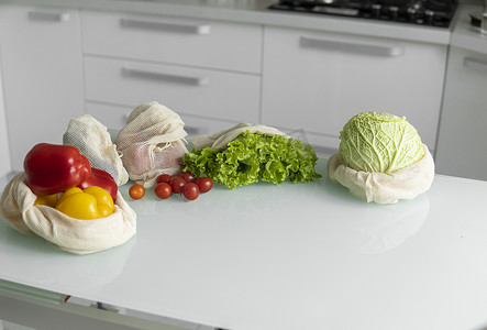 桌上可重复使用的生态棉袋中的蔬菜、水果、鸡蛋。