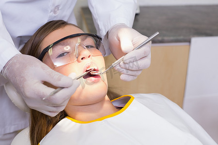 儿科牙医在牙医椅上检查病人的牙齿