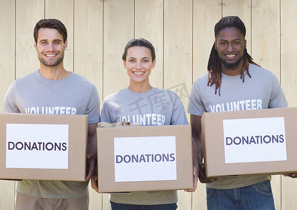 捐款箱摄影照片_三名微笑的志愿者拿着捐款箱