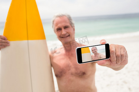 带冲浪板的老人在手机上自拍