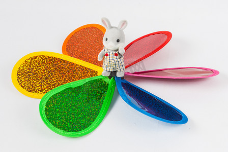 站在彩色风车中间的玩具兔子