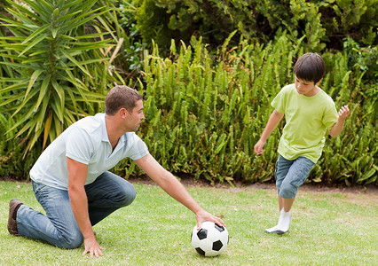 儿子和他父亲踢足球