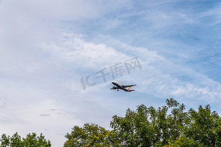 飞行痕迹摄影照片_在蓝天飞行的客机有云彩，巡航飞机，运输业