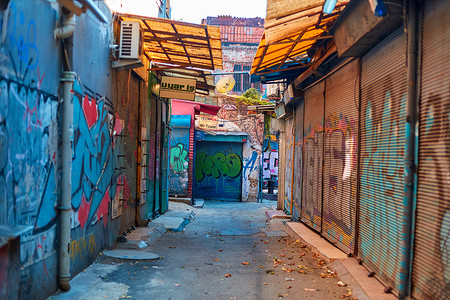 涂鸦摄影照片_布满涂鸦的狭窄市场街道。