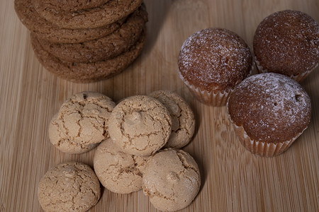 松饼、杏仁意大利杏仁饼干和燕麦饼干放在木架板上。