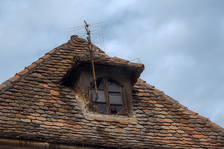 有地衣和老电视天线的罗马尼亚陶瓷瓦屋顶