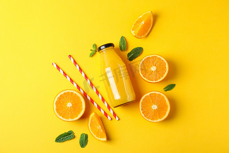 销售文字摄影照片_瓶中装有橙子、小管和橙汁的平躺式组合物，文字空间。