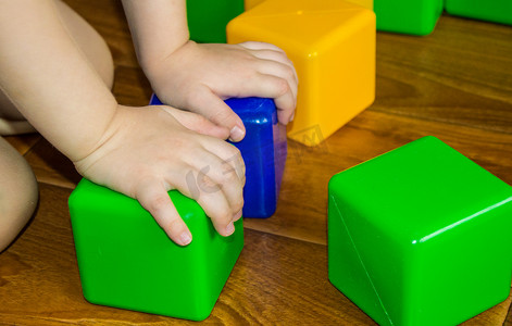 一个玩彩色方块的小孩建塔，这是为学校发展做早教准备的概念
