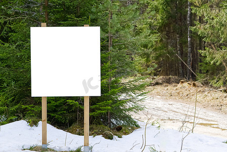 森林中的白色信息海报或空白广告牌占位符。