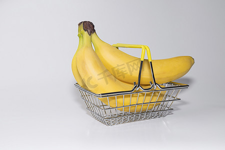 特写商品摄影照片_钢铁超市网格中的香蕉特写