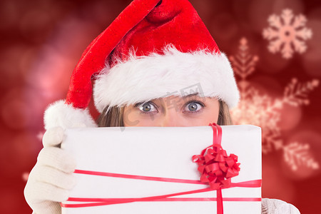 礼物盒精致摄影照片_拿着礼物盒的圣诞老人帽子的妇女