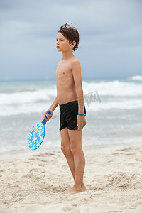 玩球小孩摄影照片_夏天在沙滩上玩沙滩球的快乐小孩男孩