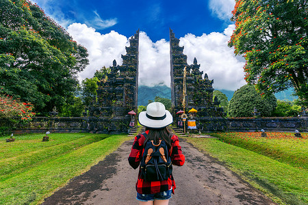 背着背包的女游客在印度尼西亚巴厘岛的大门前行走。