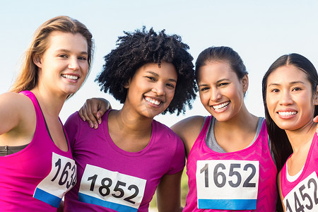 四位微笑的赛跑者支持乳腺癌马拉松