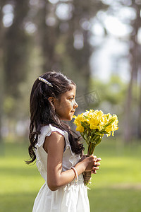 穿着白色裙子，手里拿着一束可爱的花的小女孩