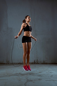 健身会馆摄影照片_使用跳绳的运动女人。