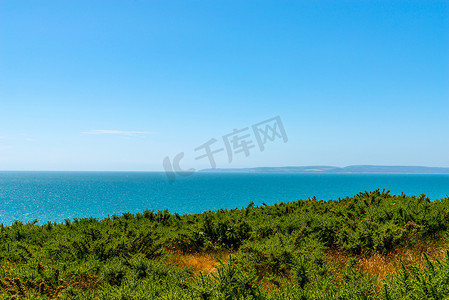 与小山、绿色植被背景和美丽的蓝色海洋瓦片的海景