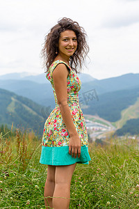 快乐的美女在山上欣赏山景，穿着夏装，山景令人叹为观止
