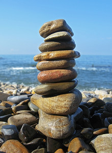 手绘石头水池摄影照片_在海边夏日的平衡的石头