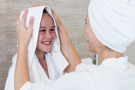 家长早睡摄影照片_母亲用毛巾擦干女儿的头发