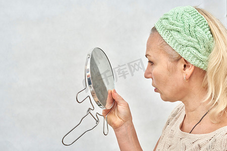 老人化妆摄影照片_一个年迈的女人在化妆前照镜子