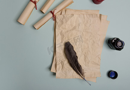 红色背景上的乌鸦羽毛、墨水瓶和旧黄纸。