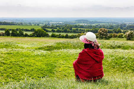 女人坐在田里欣赏农田的景色