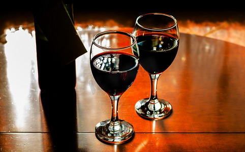 干杯时刻摄影照片_一杯红酒，用一杯酒庆祝一个时刻，为美食家提供精美的酒