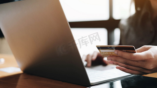 女人的手拿着智能手机和使用信用卡进行在线购物。