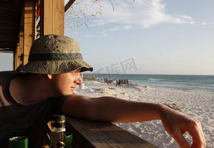 一个男人从海边酒吧看海滩。