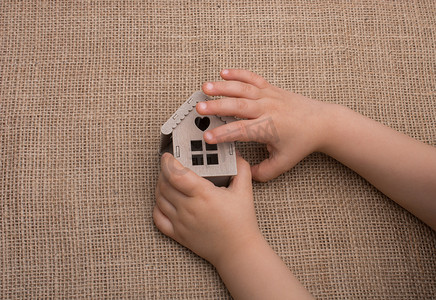 模型房子摄影照片_拿着画布上的模型房子的孩子