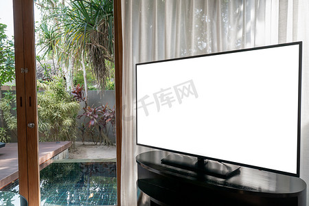 内部通道摄影照片_房间内部，大窗户白色窗帘池景观，模拟电视白色屏幕在桌子上。