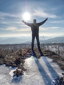 举高摄影照片_站立的人，手臂举在冰冷的石头上
